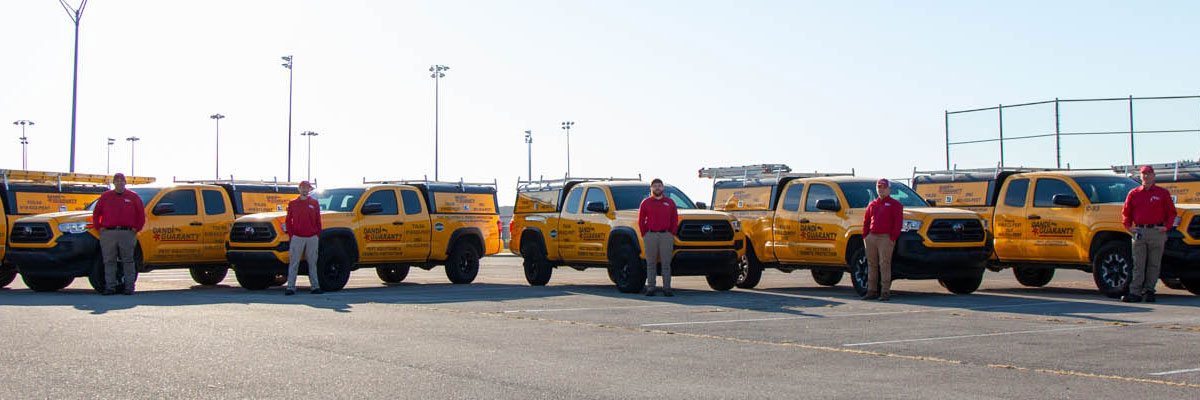 The Dandi Guaranty pest control team gathered with their branded service trucks